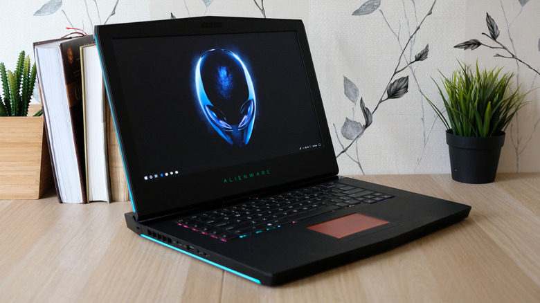 Alienware laptop opened on a desk, showing Alienware logo