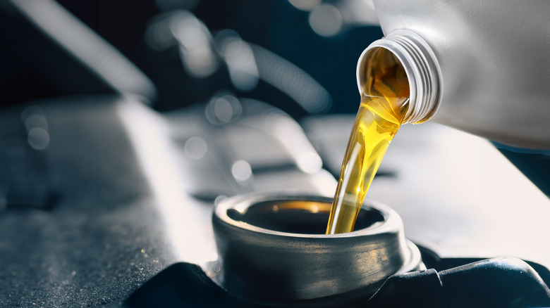 Close-up of motor oil being poured into an engine.