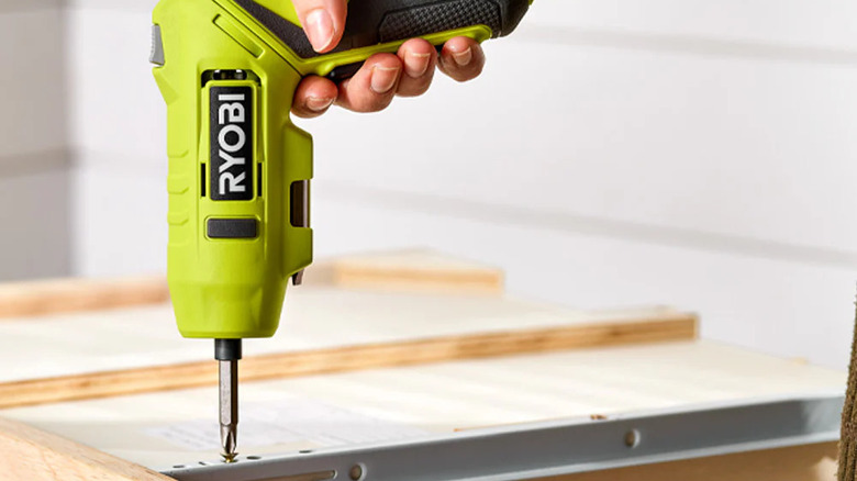 person using Ryobi electric screwdriver on wood