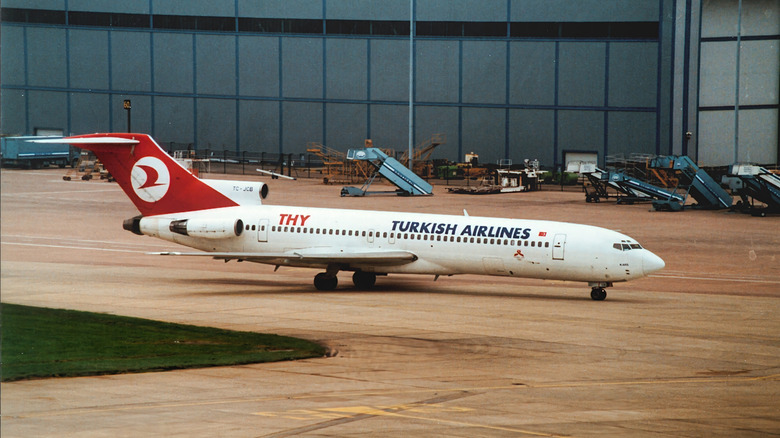 A Boeing 727 operated by Turkish Airlines on a runway, front right 3/4 view