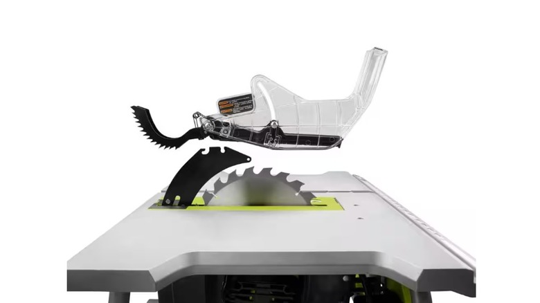 A Ryobi table saw with blade guard and riving knife visible