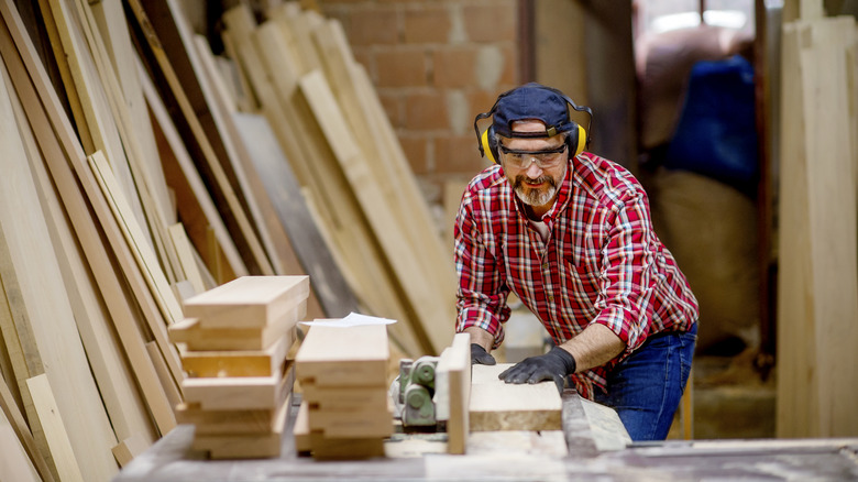 A woodworker rip cutting several planks of wood