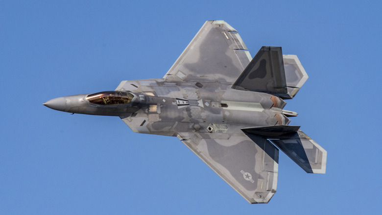 An F-22 Raptor flying over blue skies