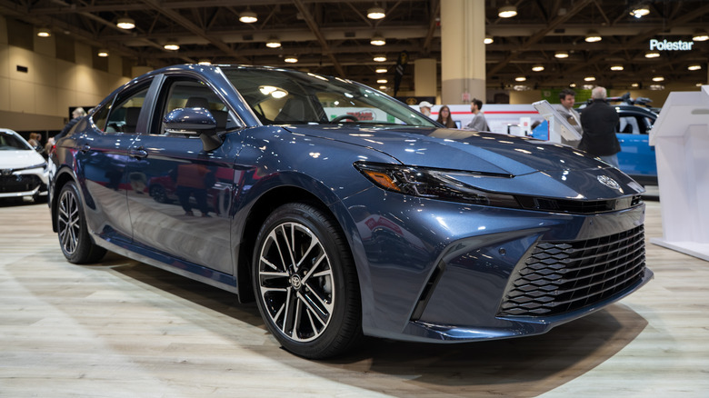 Front 3/4 view of blue 2026 Toyota Camry parked at auto show.