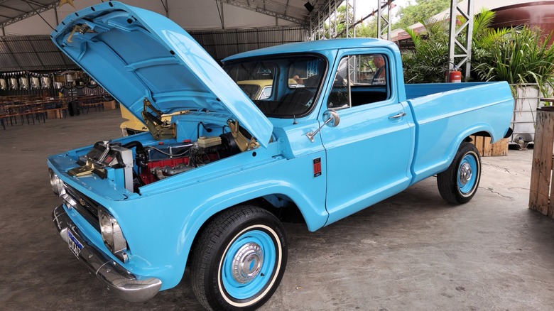 A vintage blue chevy pickup truck with the hood open