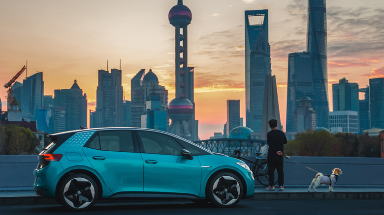 A China made EV car with the Shanghai skyline in the background