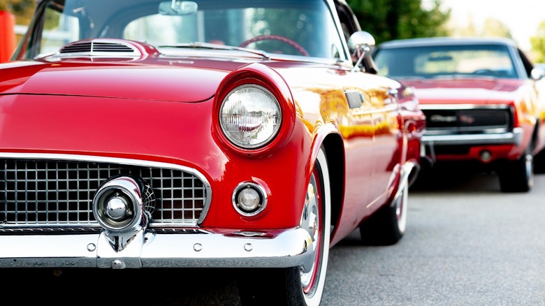 an image of two red classic cars parked near each other