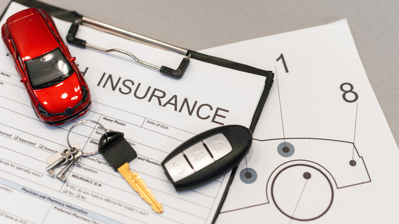 An image of car insurance paperwork with keys and a toy car over it