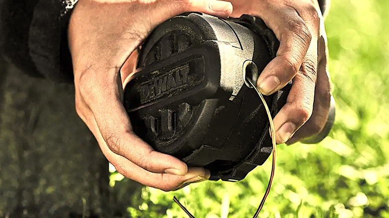 Person looking at line in DeWalt String Trimmer head
