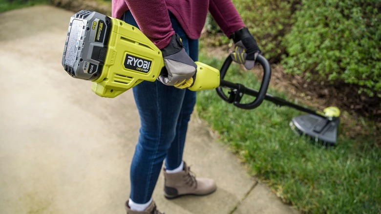 person holding ryobi trimmer