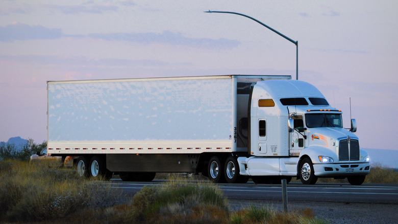 A Semi Truck With Sleeper Cab On The Road