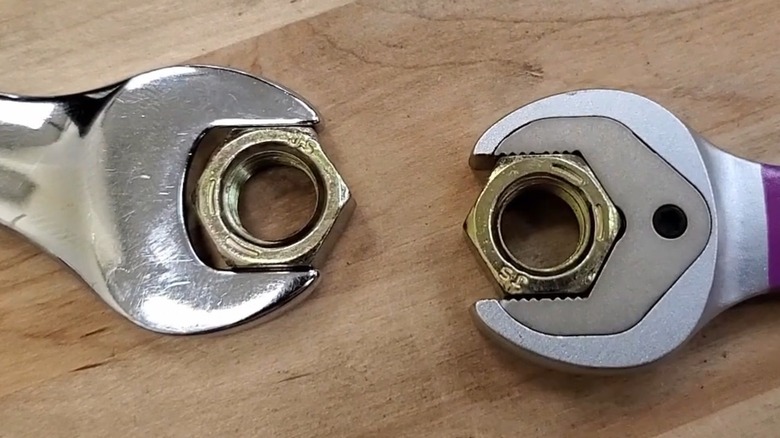 Two wrenches holding onto hex nuts.