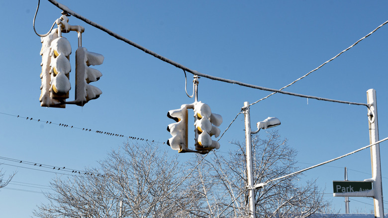 Two traffic lights at an intersection filled with snow after a winter blizzard.