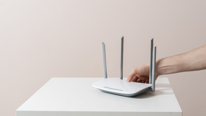 Person turning on a Wi-Fi router