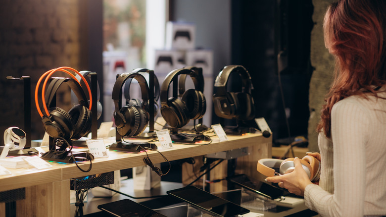 Mujer comprando auriculares en la tienda