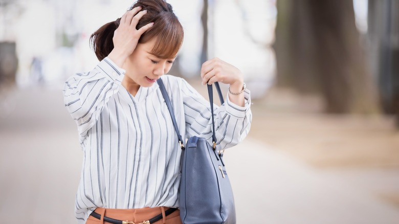 Frustrated woman holding a purse