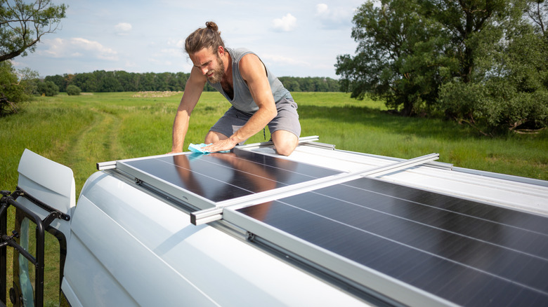 Person cleans RV solar panels