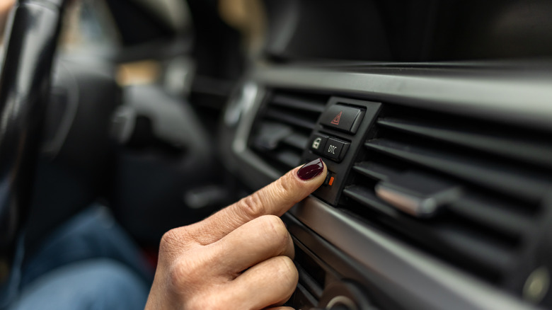 woman adjusting car AC