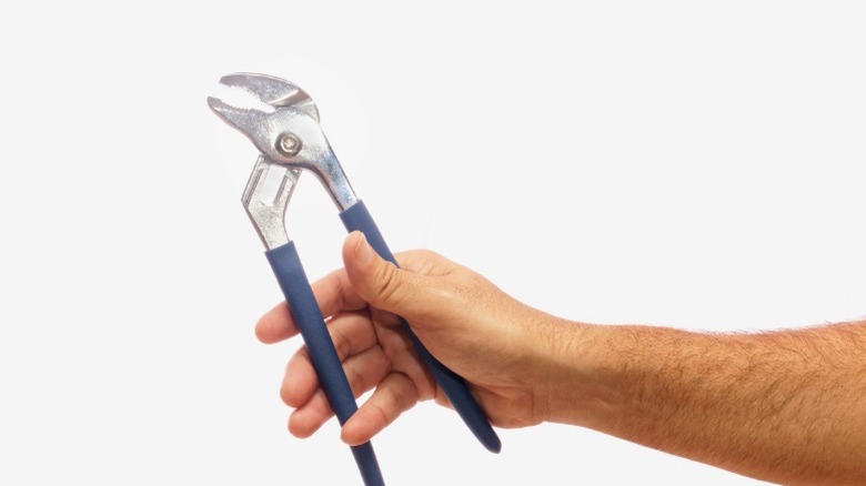 A person holding a set of channel-lock pliers