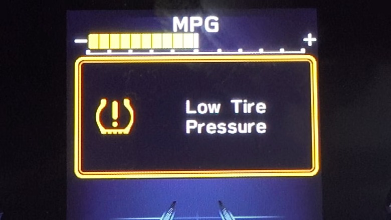 a car's dashboard showing the tpms light and a low tire pressure warning
