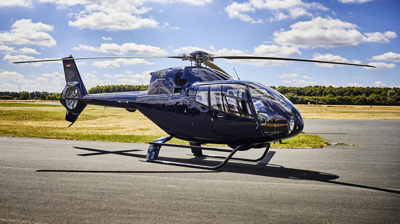 Blue helicopter on helipad on sunny day