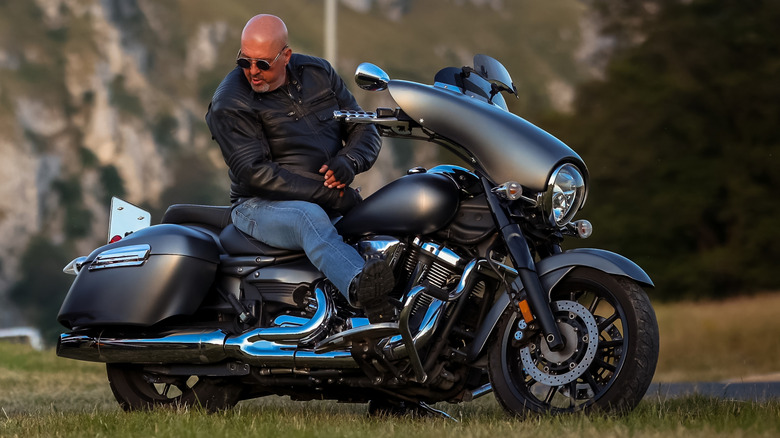 man sitting on a powerful black cruiser motorcycle