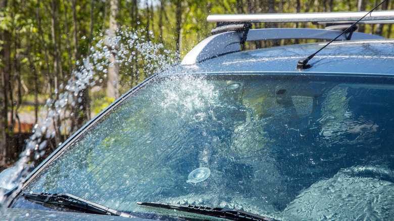 A hose running water over a car's windshield