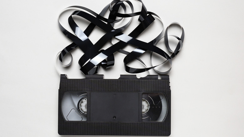 Image of an old VHS cassette with the tape spooling out.