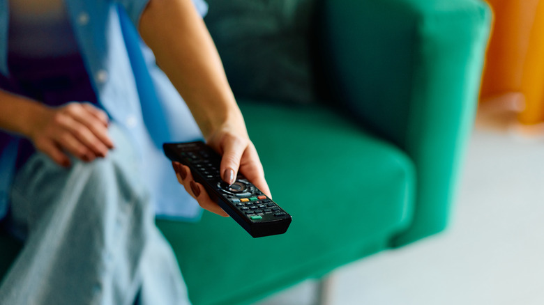 Person pointing a TV remote off-screen