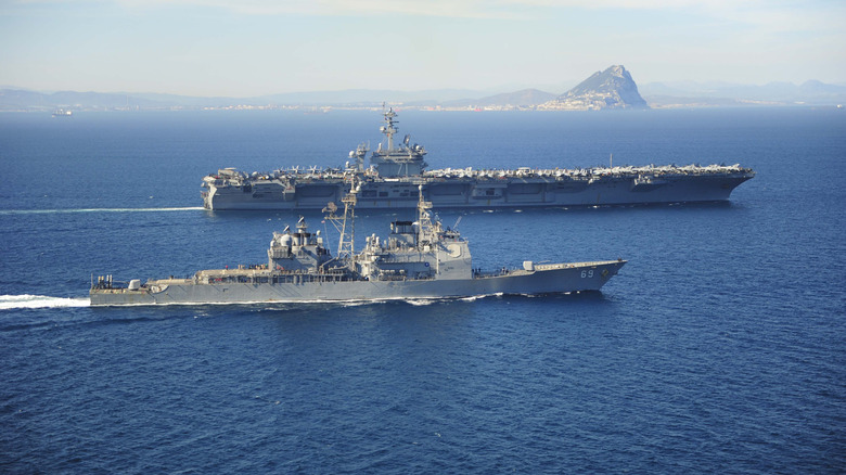 USS Vicksburg, a Ticonderoga-class guided missile cruiser escorting the Nimitz-class aircraft carrier, USS Theodore Roosevelt.