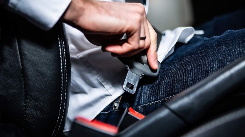 person fastening a seat belt 