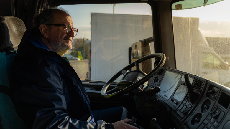 A truck driver following a long day on the road with the sunlight fading