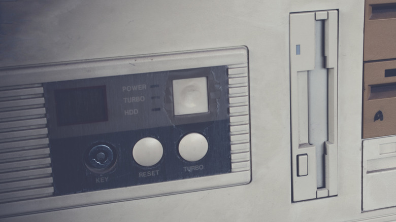 A close-up of an old 1990s personal computer showing a turbo and reset button.