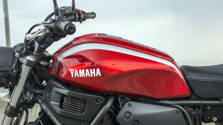 A Yamaha-branded red fuel tank on a modern Yamaha motorcycle