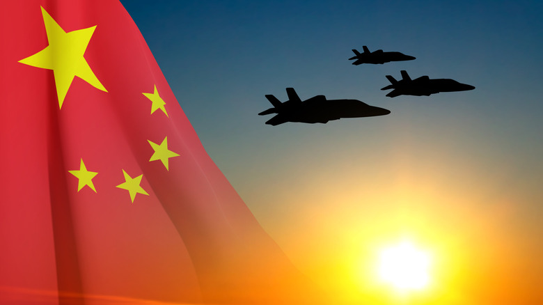 Military jets flying beside a Chinese flag.
