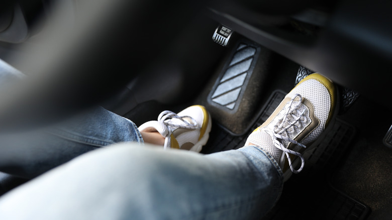 Driver pressing on brake pedal, viewed from passenger-side