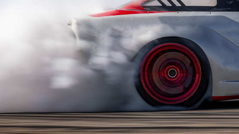 Race car performing burnout, close-up of rear-right tire