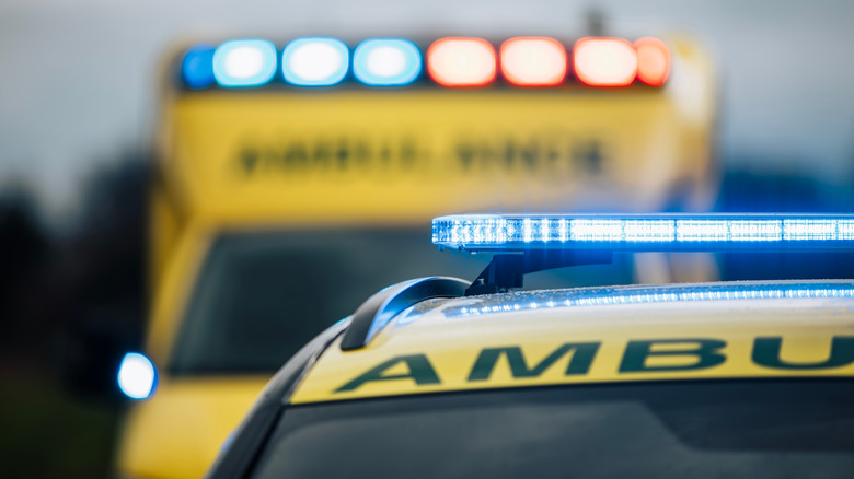 An image of two ambulance vehicles with their lights on.