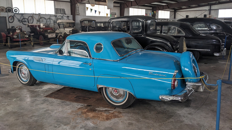Blue 1956 Ford Thunderbird on display with other antiques