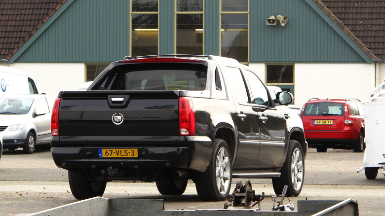 A black second generation Escalade EXT, rear 3/4 view, Netherlands plates