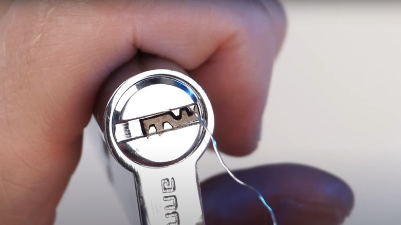 person using wire to remove broken key