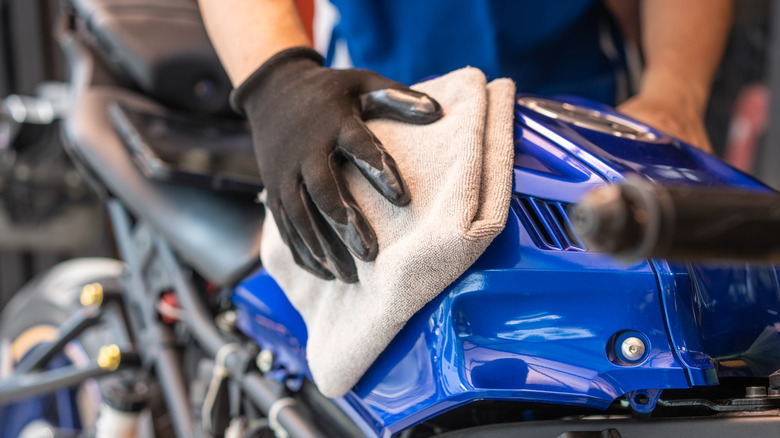 person cleaning motorcycle