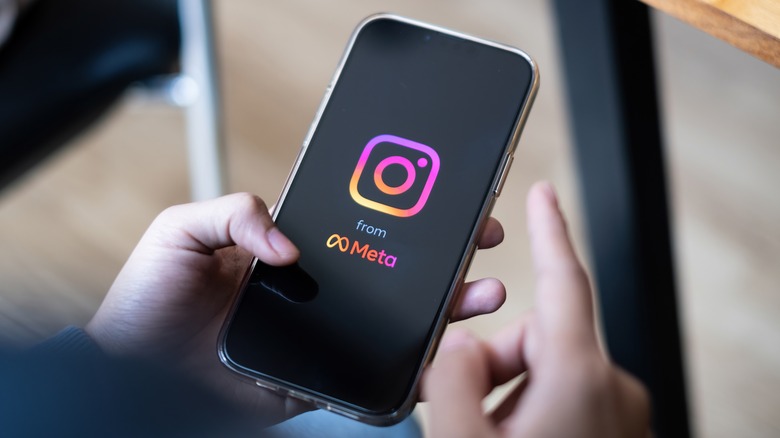 person holding smartphone with Instagram logo on the screen