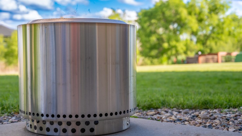 Smokeless stainless steel fire pit on backyard pavement