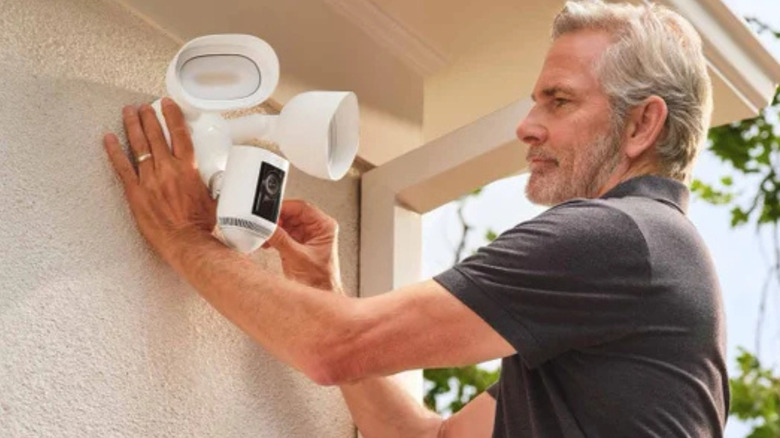 A man installing a security camera