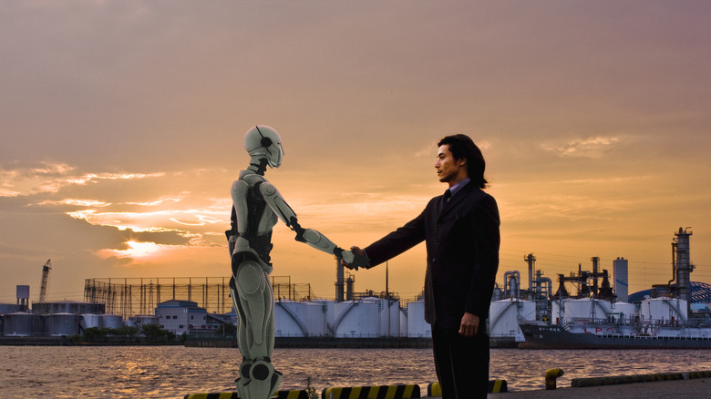 man and robot shaking hands