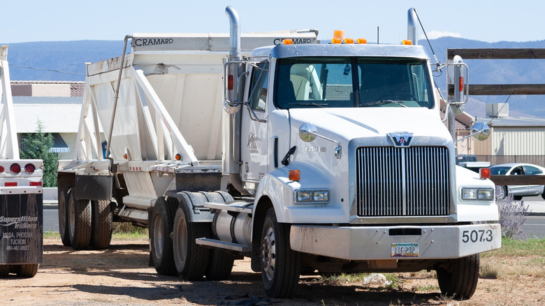 Front 3/4 view of Western Star semi truck pulling bottom dump trailer