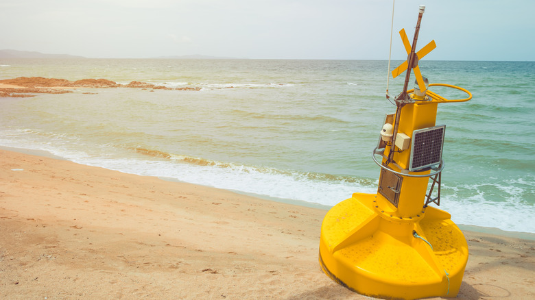 A yellow smart buoy shown on shore prepared for deployment