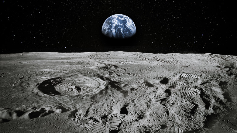 Lunar surface with footprints on it and Earth in the background