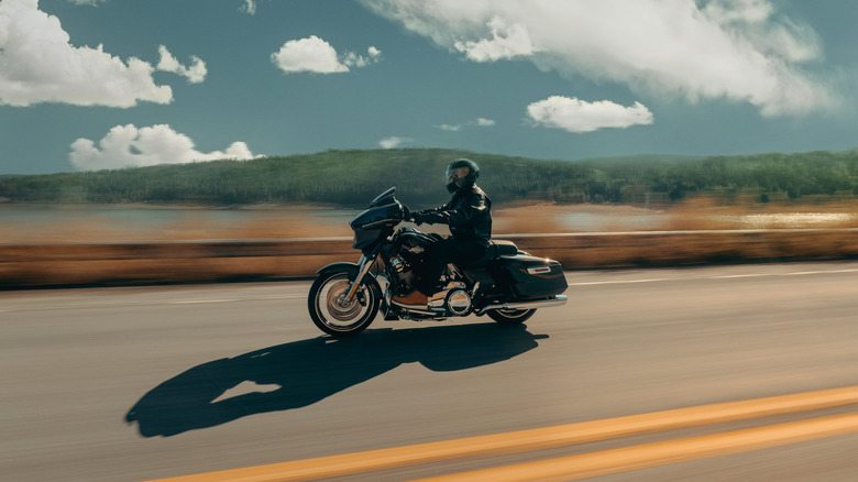 A black Harley Davidson Road Glide on the move, side view